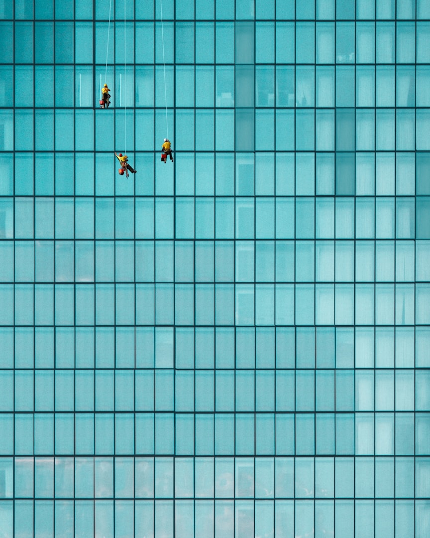 A person using a window squeegee to clean a glass surface.